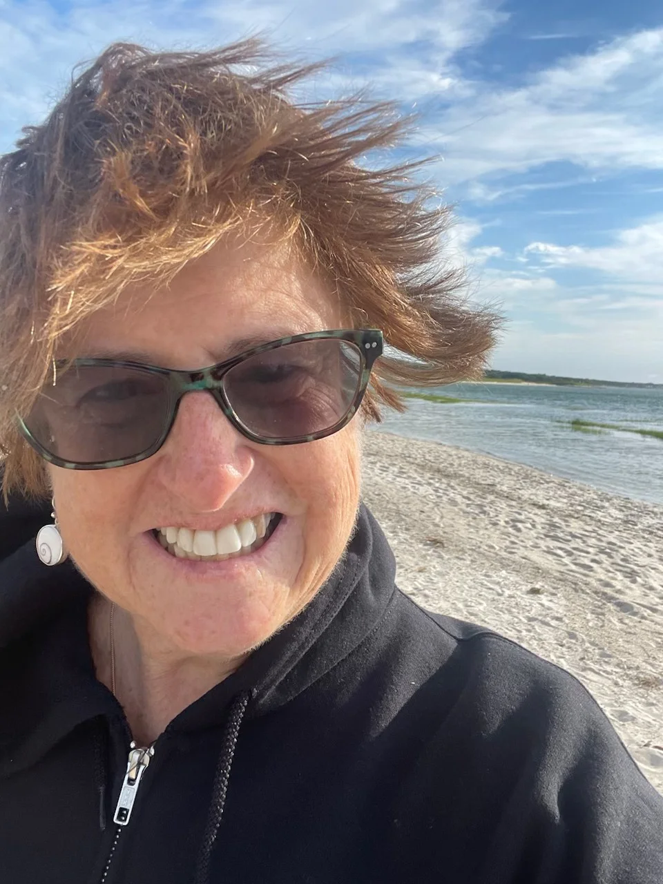 Nancy Hirsch smiling on a windy beach